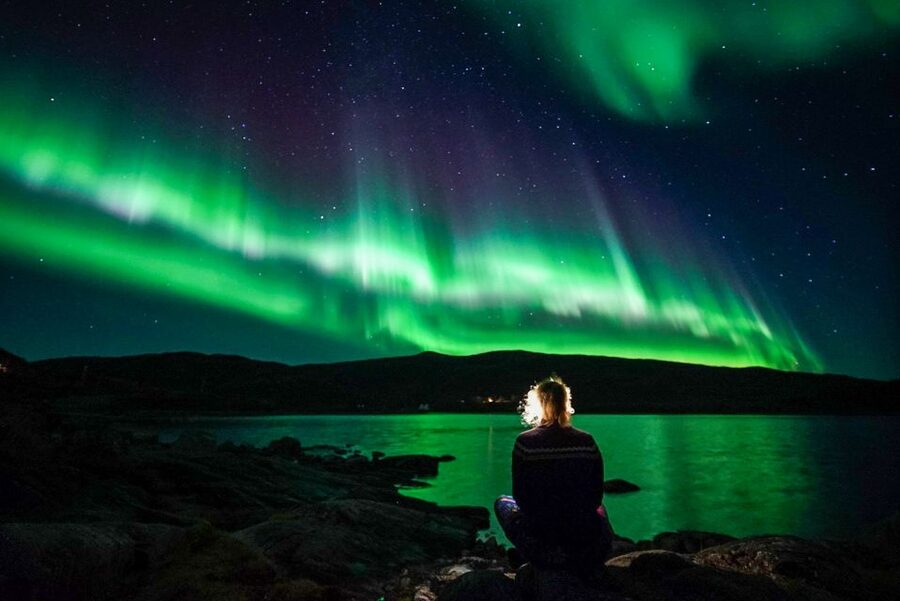 Green aurora over a fjord outside Tromsø